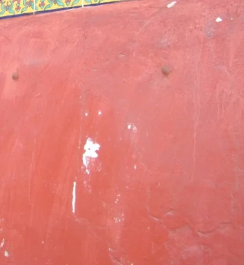 A weathered red painted wall beside the entrance of Café Flor in 2010